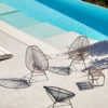Acapulco-Chair-Hocker Acapulco Chair Hocker mit Original Acapulco Chairs auf Terrasse neben Pool