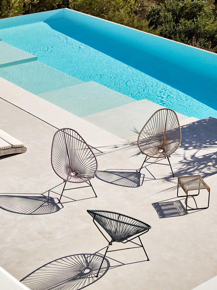 Acapulco-Chair-Hocker Acapulco Chair Hocker mit Original Acapulco Chairs auf Terrasse neben Pool